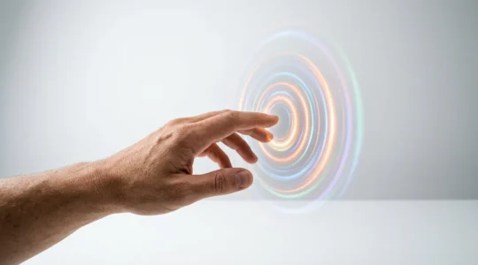 Un doigt humain interagit avec une interface holographique flottante dans un espace minimaliste, créant des ondulations lumineuses colorées